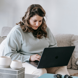 an image of a woman in her home focused on her laptop to signify the importance of focus as a remote worker